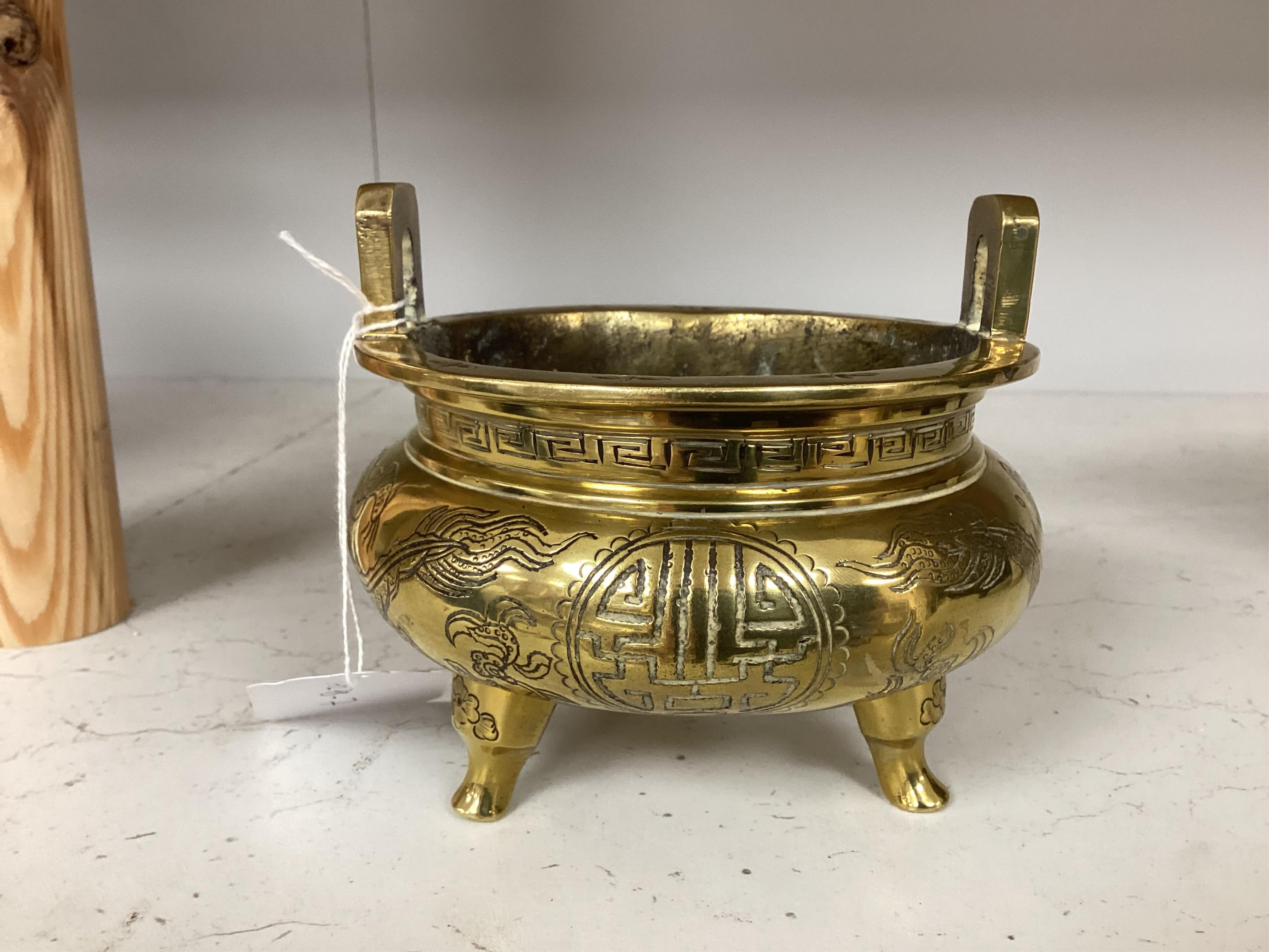 A Chinese engraved and chased bronze tripod censer, Xuande mark, early 20th century, 10.5cm. Condition - good